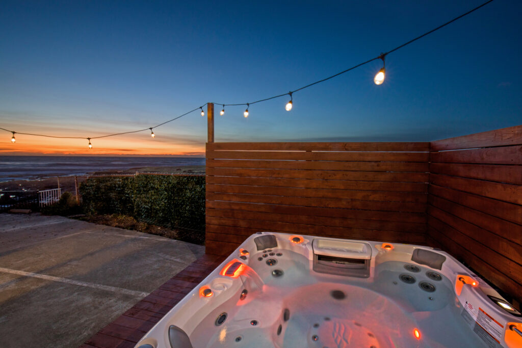 A Hot Tub on a Wooden Deck with a View of the Ocean in the Evening in Shelter Cove, CA