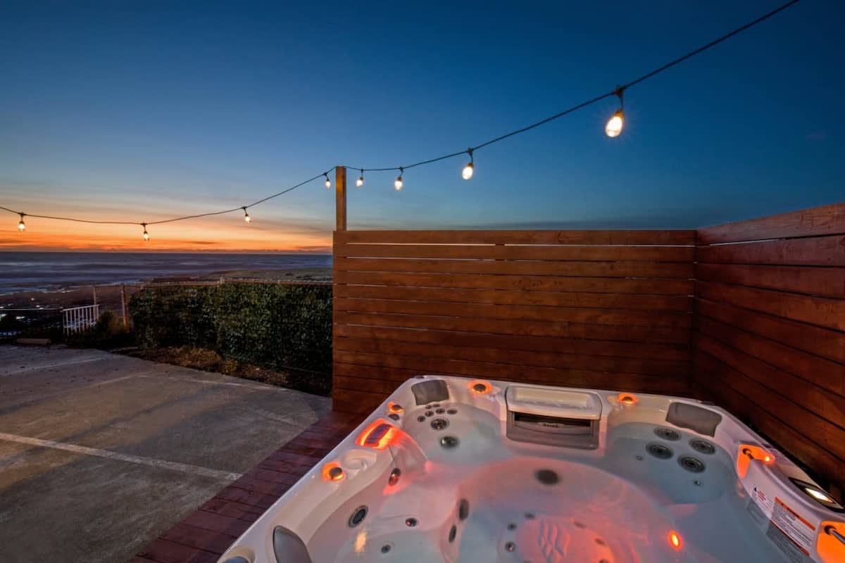 A Hot Tub on a Wooden Deck with a View of the Ocean in the Evening in Shelter Cove, CA