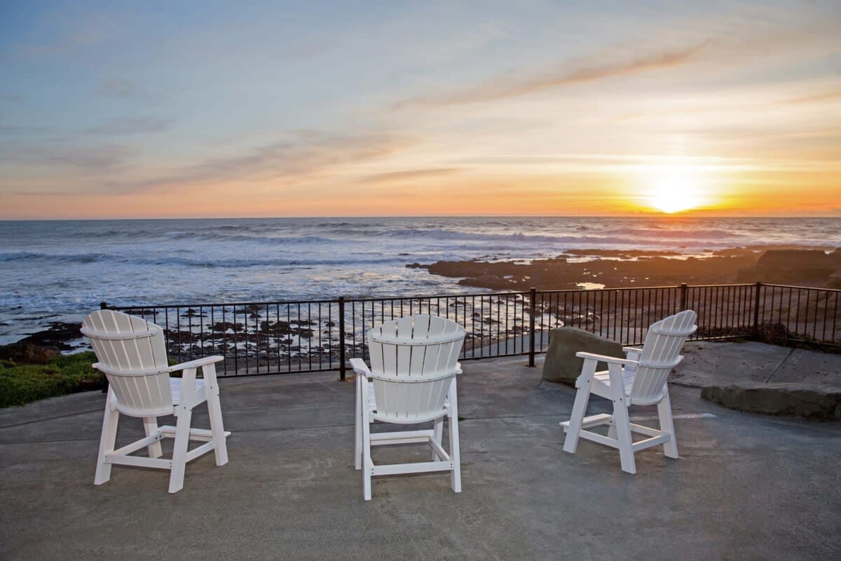 Three chairs positioned on a concrete patio in Shelter Cove, CA