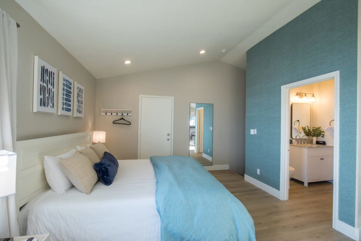 A Bedroom with a Blue and White Bed with Soft Lighting in Shelter Cove, CA