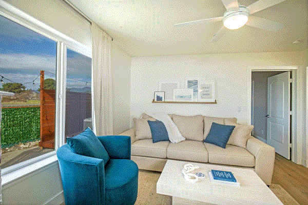 Modern living room with a blue couch and white coffee table at The Black Sands Inn