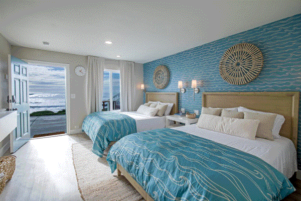 Cozy bedroom with two beds, blue walls, and relaxing design at Redwood's The Black Sands Inn.